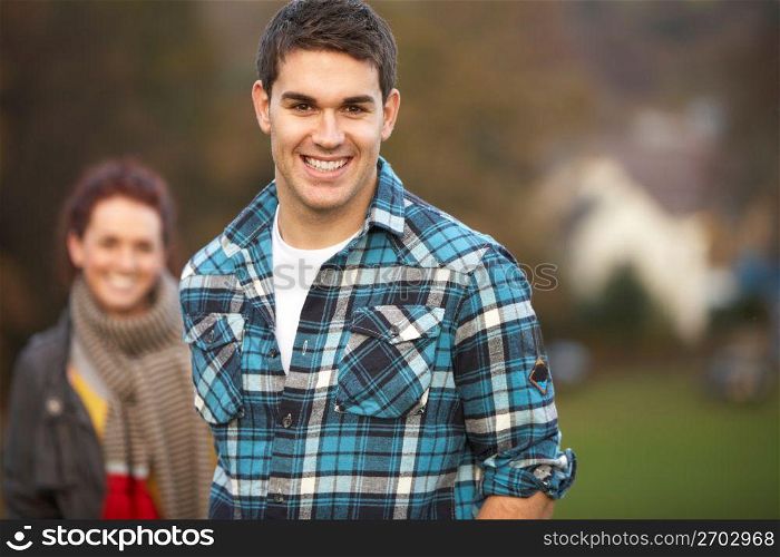 Teenage Boy Outside With Girlfriend In Background
