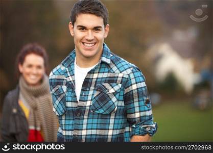 Teenage Boy Outside With Girlfriend In Background
