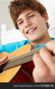 Teenage boy playing acoustic guitar