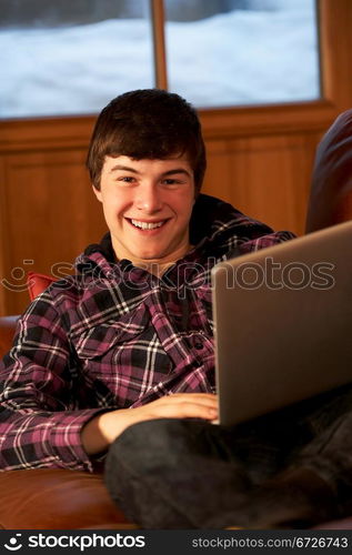 Teenage Boy Relaxing On Sofa With Laptop