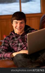 Teenage Boy Relaxing On Sofa With Laptop