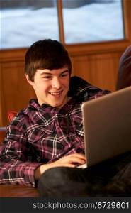 Teenage Boy Relaxing On Sofa With Laptop
