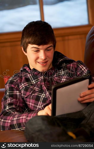 Teenage Boy Relaxing On Sofa With Tablet Computer