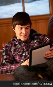 Teenage Boy Relaxing On Sofa With Tablet Computer