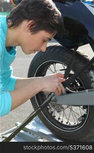Teenage boy repairing motorcycle