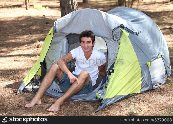 Teenage boy sat in tent