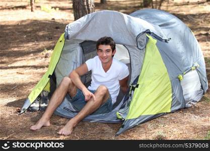 Teenage boy sat in tent