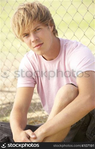 Teenage Boy Sitting In Playground