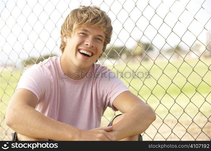 Teenage Boy Sitting In Playground