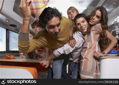 Teenage boy struggling his way through a group of people in a motor home