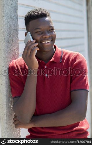 Teenage Boy Talking Outside On Mobile Phone In Urban Setting