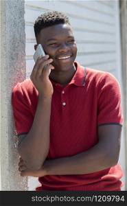 Teenage Boy Talking Outside On Mobile Phone In Urban Setting