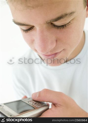 Teenage boy using cellular phone and smiling