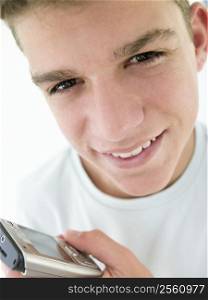 Teenage boy using cellular phone and smiling