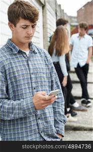 Teenage Boy Using Mobile Phone In Urban Setting