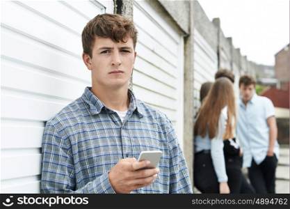 Teenage Boy Using Mobile Phone In Urban Setting