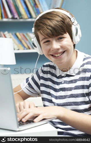 Teenage Boy Using Technology In Bedroom