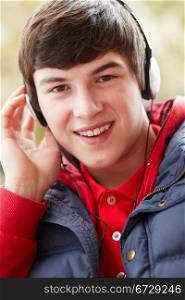 Teenage Boy Wearing Headphones And Listening To Music Wearing Winter Clothes