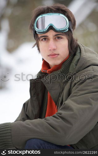 Teenage Boy Wearing Winter Clothes In Snowy Landscape