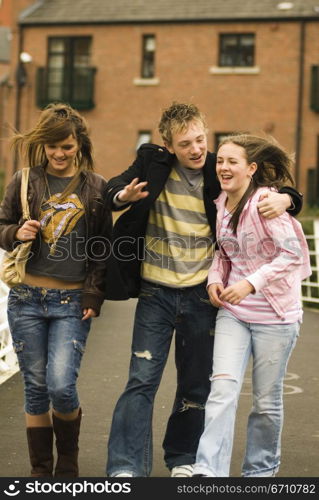 Teenage boy with two teenage girls walking together