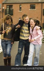 Teenage boy with two teenage girls walking together