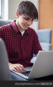 Teenage Boy Working On Laptop At Home