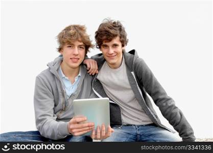 Teenage boys sitting outside with electronic tablet