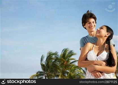 Teenage couple (16-17) embracing on beach