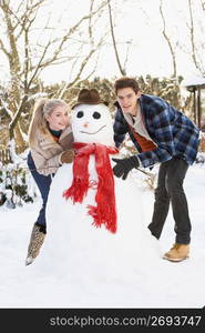 Teenage Couple Building Snowman