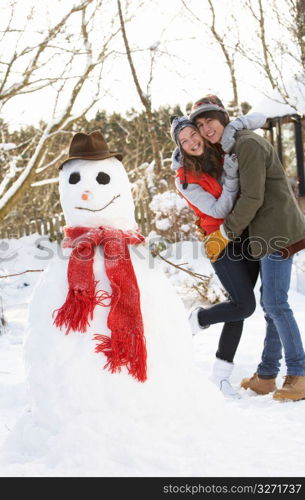 Teenage Couple Building Snowman