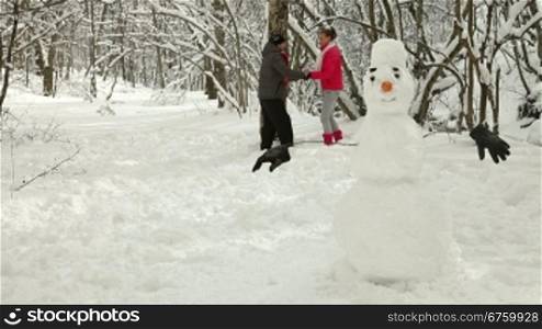 Teenage Couple Enjoying Winter Holidays in Snowy Forest