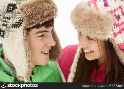 Teenage Couple In Snow Wearing Fur Hats