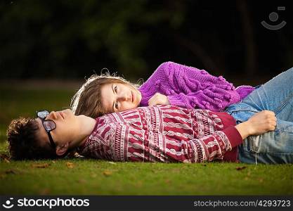 Teenage couple laying in grass in park