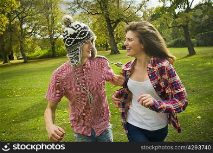 Teenage couple running in park