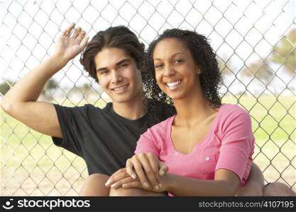 Teenage Couple Sitting In Playground