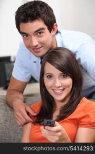 Teenage couple with television remote control