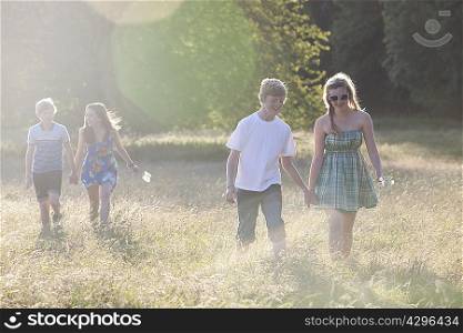 Teenage couples walking in field