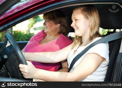 Teenage daughter gets a driving lesson from her mother or an instructor.