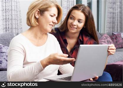 Teenage Daughter Showing Mother How To Use Laptop Computer