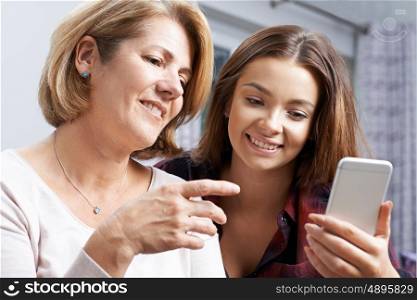 Teenage Daughter Showing Mother How To Use Mobile Phone