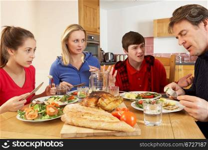 Teenage Family Having Argument Whilst Eating Lunch Together In Kitchen