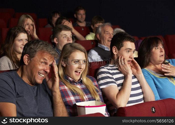Teenage Family Watching Film In Cinema