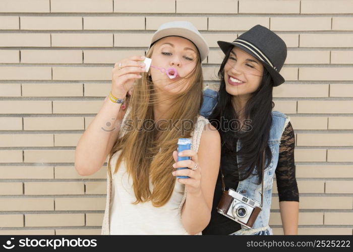 Teenage firends playing with soap bubbles