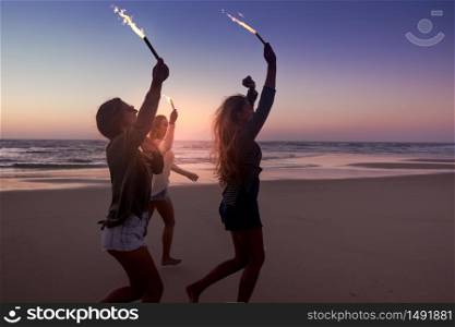 Teenage friends running on a beach with fireworks