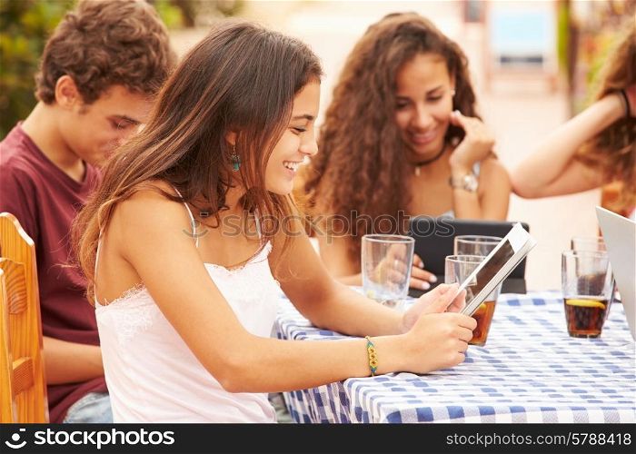 Teenage Friends Sitting At Caf? Using Digital Devices
