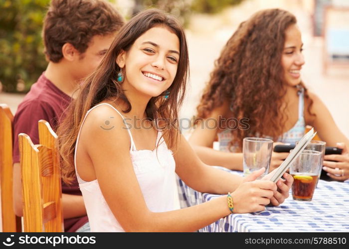 Teenage Friends Sitting At Caf? Using Digital Devices