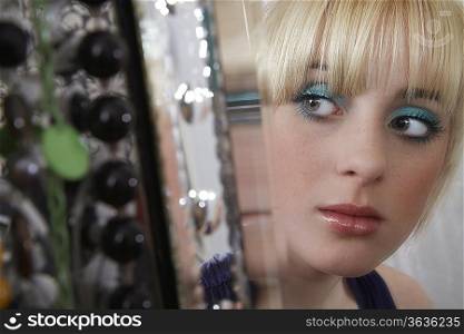 Teenage girl (16-17) looking in mirror