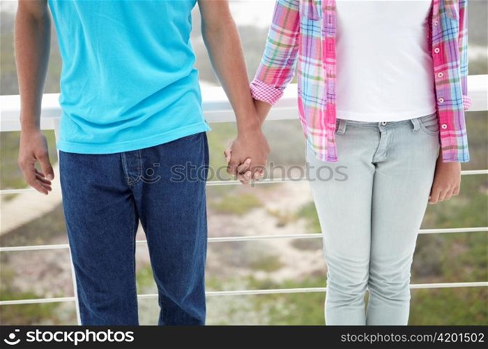 Teenage girl and boy holding hands