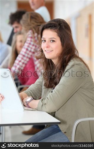 Teenage girl at school using electronic tablet
