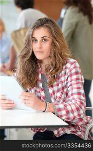 Teenage girl at school using electronic tablet